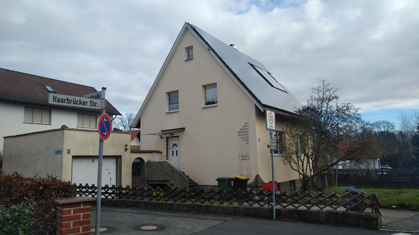 Vermitteltes Einfamilienhaus an einer Straßenecke mit Photovoltaik